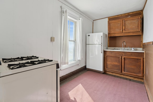 9 S 11th St, Newark, OH 43055 - kitchen featuring a wealth of natural light, a sink, brown cabinets, and white appliances