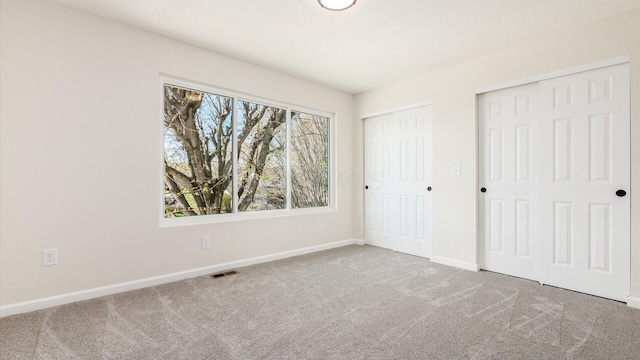 500 Hemlock Pl, Newark, OH 43055 - unfurnished bedroom featuring baseboards, visible vents, carpet, and two closets