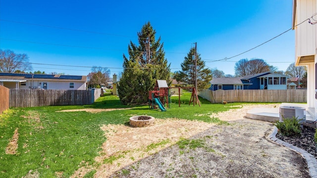 500 Hemlock Pl, Newark, OH 43055 - view of yard featuring central air condition unit, an outdoor fire pit, a fenced backyard, and a playground