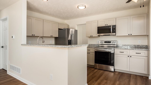 500 Hemlock Pl, Newark, OH 43055 - kitchen with visible vents, dark wood-type flooring, a peninsula, appliances with stainless steel finishes, and ceiling fan