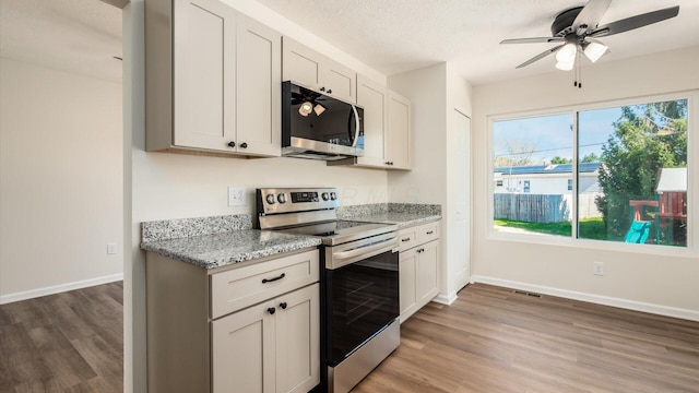 500 Hemlock Pl, Newark, OH 43055 - kitchen featuring stainless steel appliances, light stone counters, light wood-type flooring, baseboards, and ceiling fan