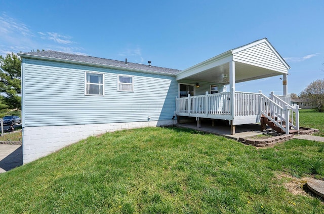 rear view of property featuring a yard and a deck