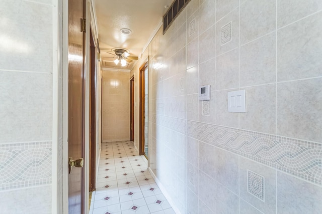 5072 Teddy Dr, Columbus, OH 43227 - hallway featuring visible vents, tile walls, and light tile patterned flooring