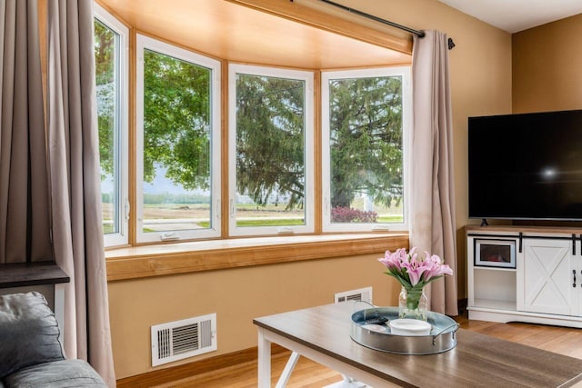 interior space featuring visible vents, wood finished floors, and a healthy amount of sunlight