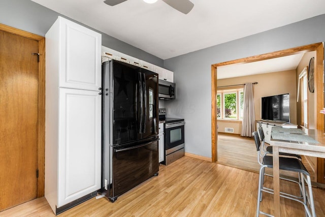 kitchen with visible vents, light wood finished floors, white cabinetry, and stainless steel appliances
