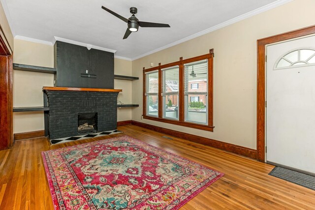 1297 S 4th St, Columbus, OH 43206 - living room with a ceiling fan, wood finished floors, a fireplace, and crown molding