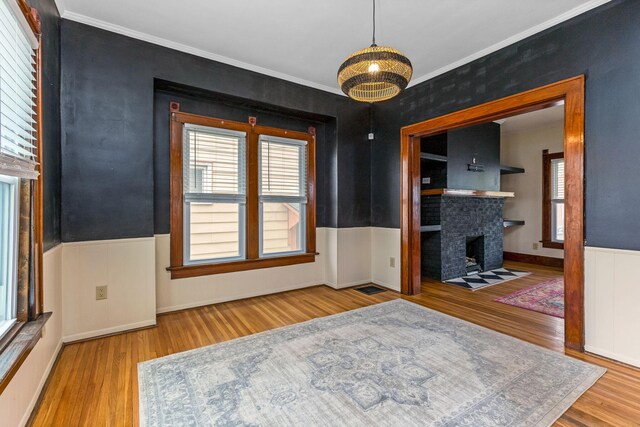 1297 S 4th St, Columbus, OH 43206 - dining space featuring ornamental molding, a healthy amount of sunlight, wood finished floors, and a fireplace