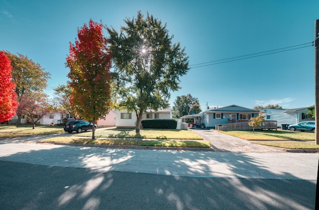 view of front of property featuring a front yard, a residential view, driveway, and covered porch