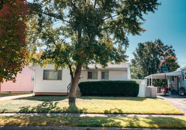 view of front of home featuring a carport, a front lawn, and fence