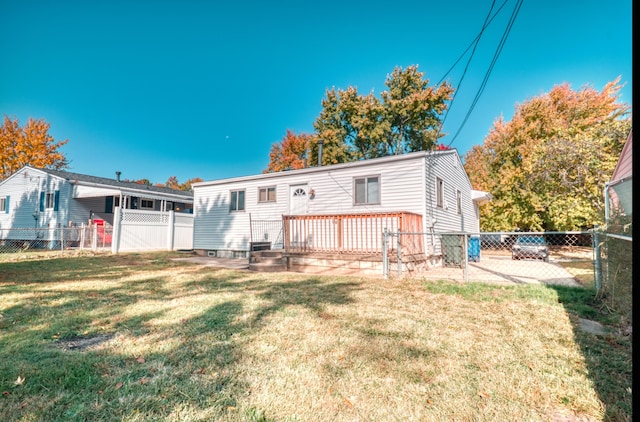 rear view of house with a wooden deck, fence private yard, and a lawn