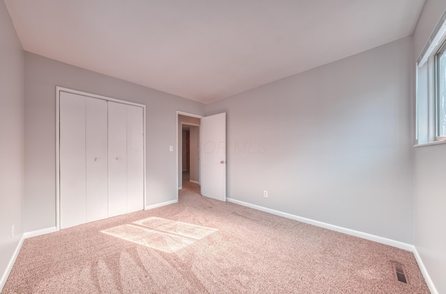 unfurnished bedroom featuring a closet, baseboards, and carpet floors