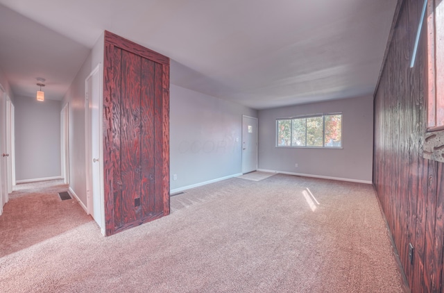 carpeted spare room with visible vents and baseboards