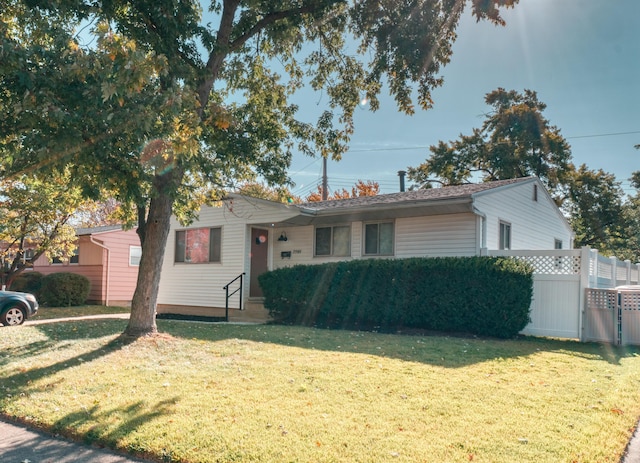 ranch-style home with a front yard and fence