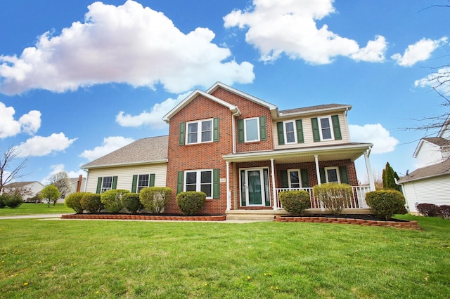 view of front of house featuring brick siding, covered porch, and a front yard