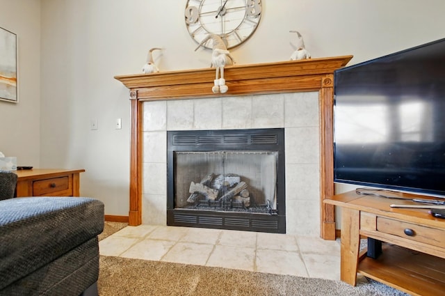 details featuring a tiled fireplace, baseboards, and carpet floors