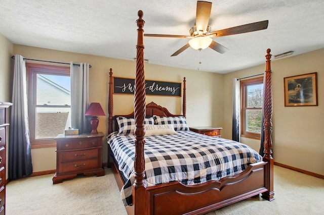 bedroom featuring ceiling fan, light colored carpet, baseboards, and a textured ceiling
