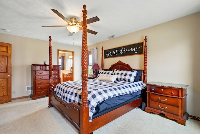 bedroom with ensuite bath, baseboards, a ceiling fan, and light colored carpet