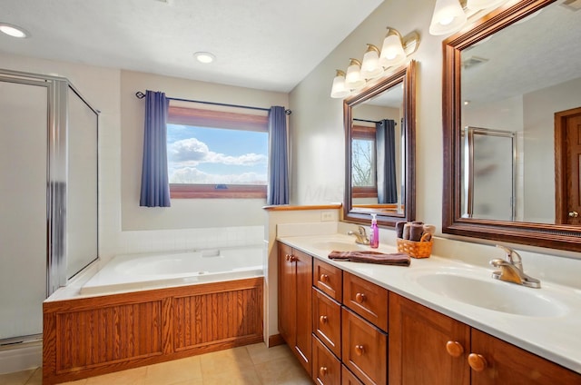 bathroom with a shower stall, double vanity, a garden tub, and a sink