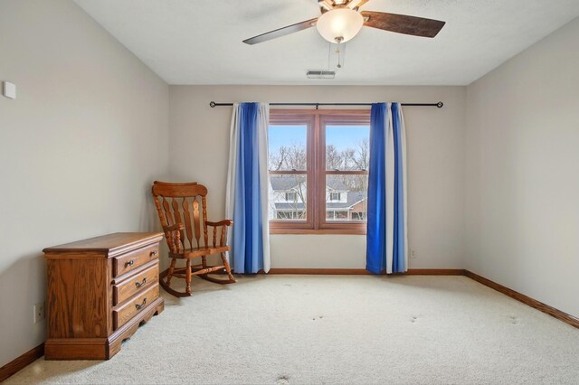 living area with visible vents, a ceiling fan, baseboards, and carpet flooring