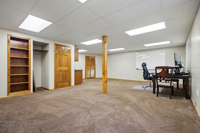 finished below grade area featuring carpet flooring, baseboards, and a drop ceiling