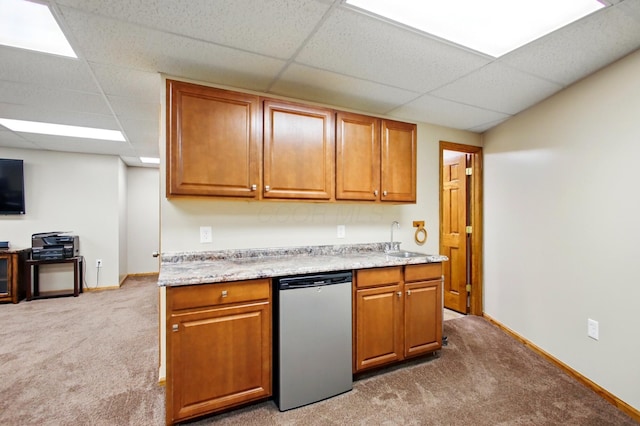 kitchen featuring brown cabinets, a paneled ceiling, light colored carpet, and dishwasher