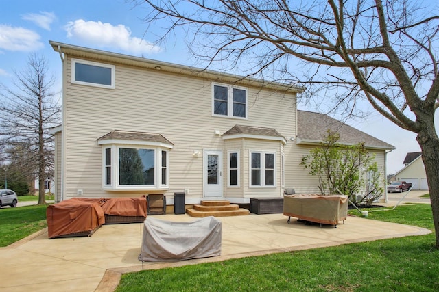 rear view of property with a patio area, a lawn, a shingled roof, and entry steps