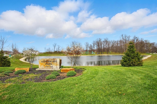 community / neighborhood sign with a lawn and a water view