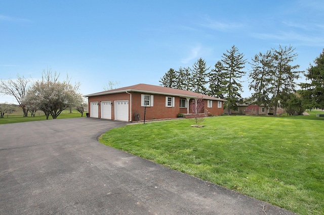 ranch-style house with brick siding, a front lawn, a garage, and driveway