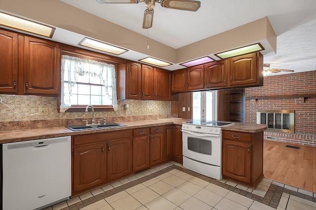 kitchen featuring a sink, a ceiling fan, white appliances, and a peninsula