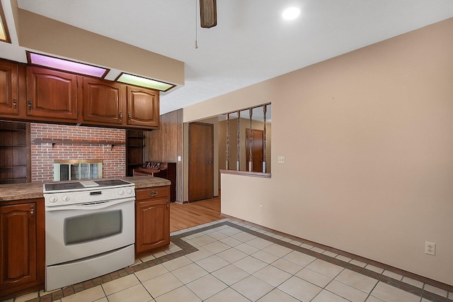 kitchen featuring electric range, open shelves, and light tile patterned flooring