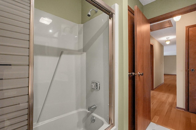 full bathroom with shower / washtub combination and wood finished floors