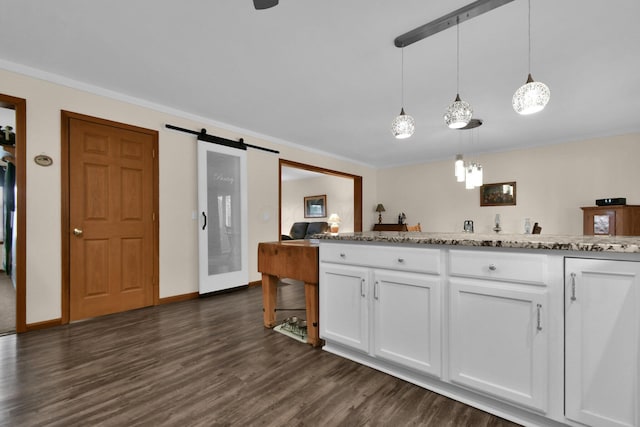 191 Craig Dr, Thornville, OH 43076 - kitchen featuring hanging light fixtures, white cabinets, a barn door, light stone countertops, and dark wood-type flooring