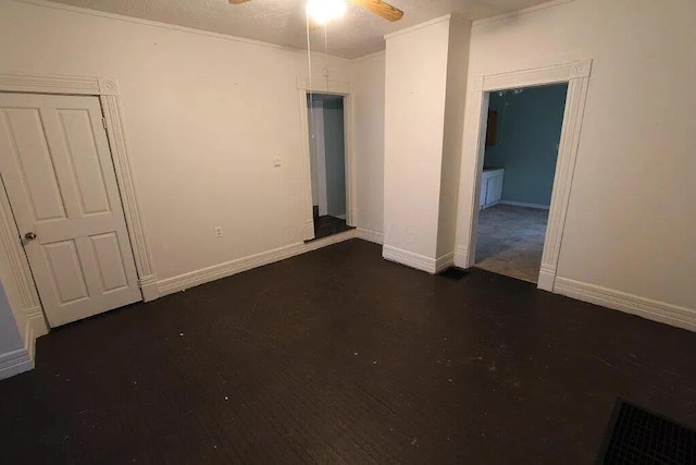 unfurnished room featuring ornamental molding, a ceiling fan, visible vents, wood finished floors, and baseboards