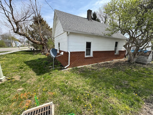 6927 Rings Rd, Dublin, OH 43016 - view of home's exterior featuring brick siding, a chimney, a shingled roof, and a lawn