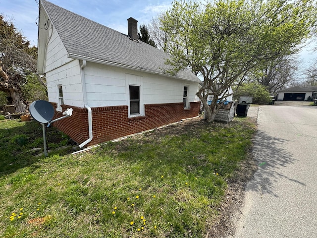 6927 Rings Rd, Dublin, OH 43016 - view of side of home with brick siding, a yard, roof with shingles, and a chimney