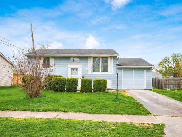 3198 Benham Ct, Columbus, OH 43232 - raised ranch featuring a garage, a front lawn, fence, and aphalt driveway