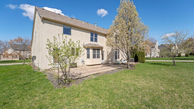 back of property featuring a patio area, a lawn, and stucco siding
