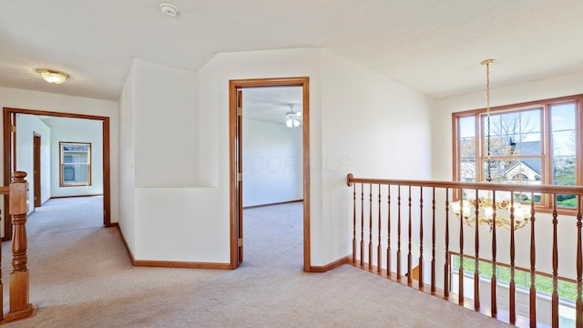 corridor with baseboards, lofted ceiling, and carpet flooring