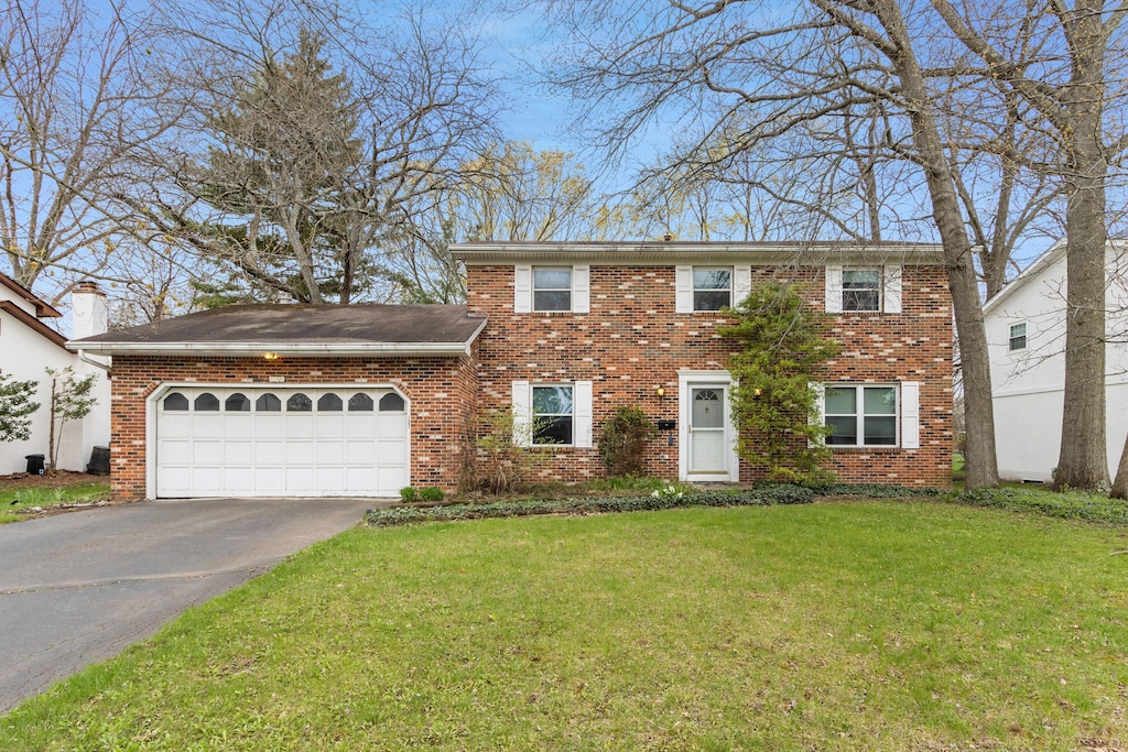 1091 Matterhorn Dr, Reynoldsburg, OH 43068 - colonial inspired home with aphalt driveway, brick siding, an attached garage, and a front yard