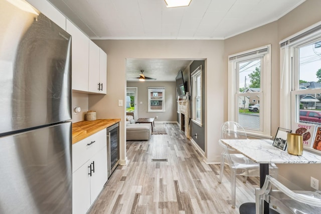 1329 Studer Ave, Columbus, OH 43206 - kitchen with freestanding refrigerator, wine cooler, butcher block counters, light wood finished floors, and white cabinetry