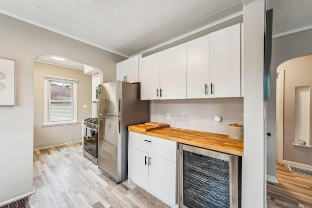 1329 Studer Ave, Columbus, OH 43206 - kitchen with wine cooler, arched walkways, crown molding, stainless steel appliances, and wooden counters