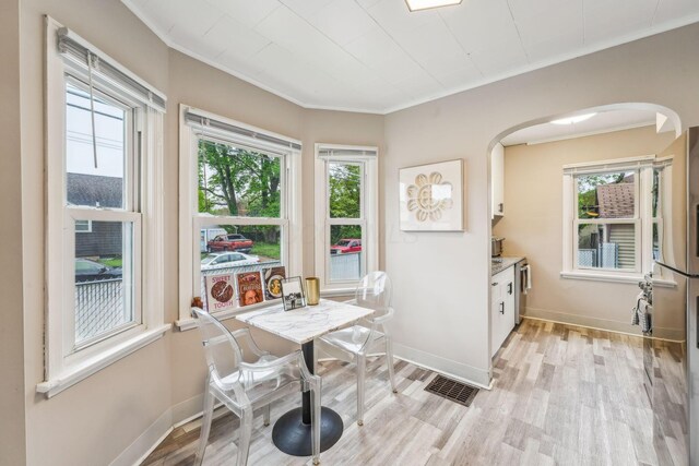 1329 Studer Ave, Columbus, OH 43206 - dining area with arched walkways, crown molding, healthy amount of natural light, and light wood-style floors