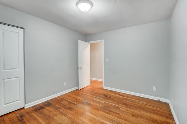 unfurnished bedroom featuring hardwood / wood-style flooring and baseboards