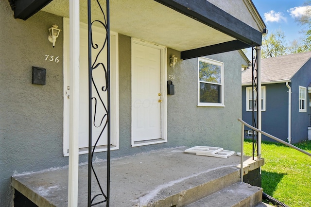 doorway to property featuring stucco siding
