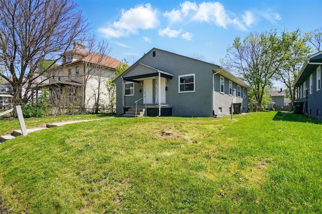 bungalow-style home featuring a front lawn and stucco siding