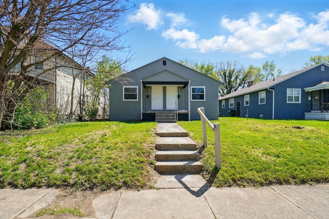 bungalow featuring stucco siding and a front yard