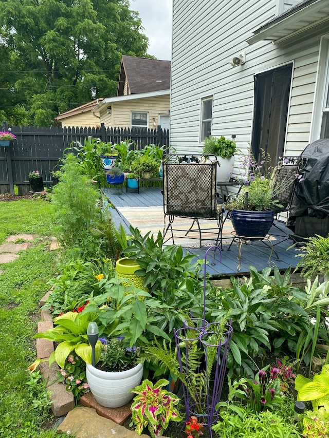 view of patio with a grill, a wooden deck, and fence
