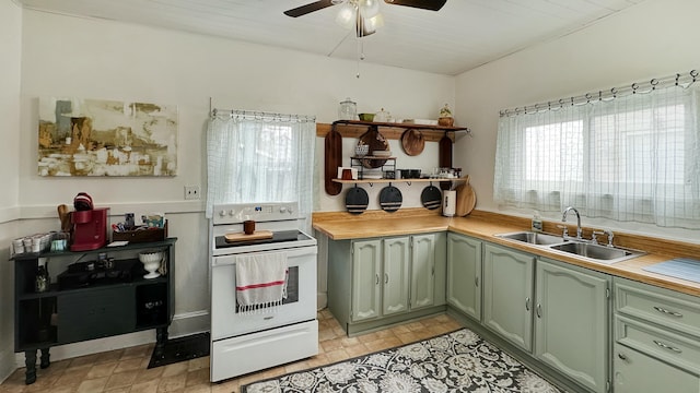kitchen featuring open shelves, green cabinetry, a sink, ceiling fan, and electric stove