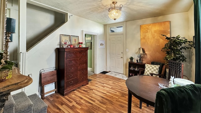foyer entrance with a chandelier, wood finished floors, and baseboards
