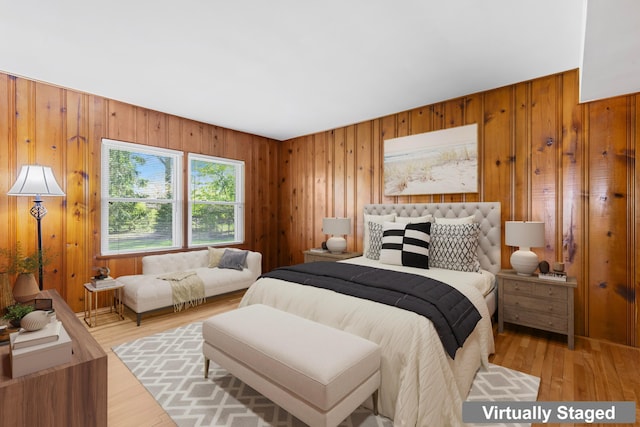 bedroom featuring wood walls and light wood-style flooring